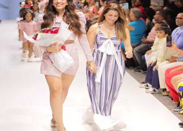 Mayra Delgado y Cosurero de Lula, desfilan delante de niñas modelos, como parte de la actividad